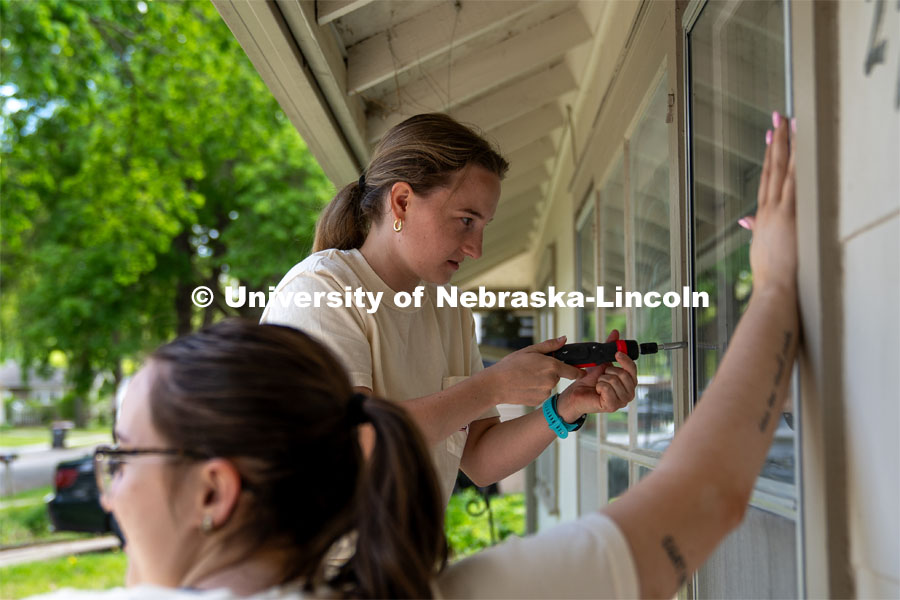 Members of Tri Delta remove and replace window guards to clean windows during the Big Event. May 4, 2024. Photo by Kirk Rangel for University Communication.